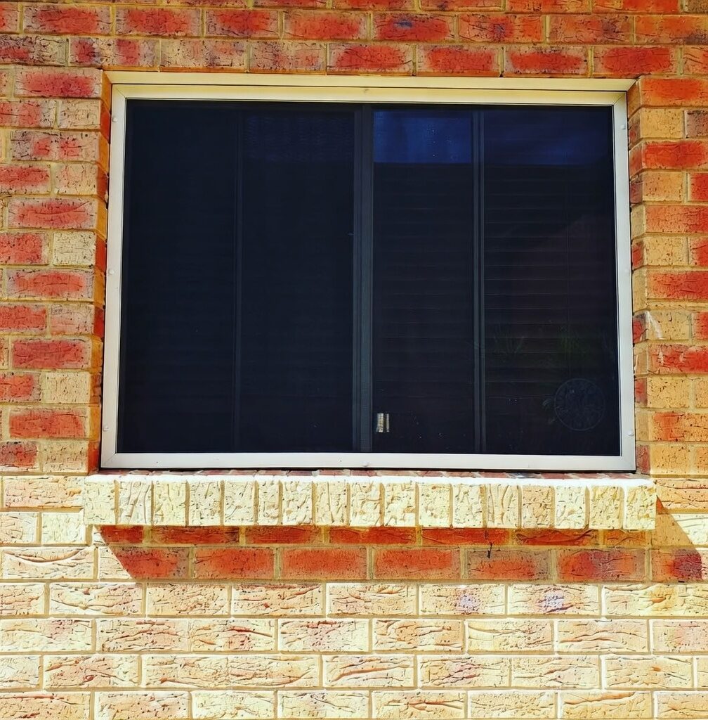Security window screen cream aluminium frame brick wall